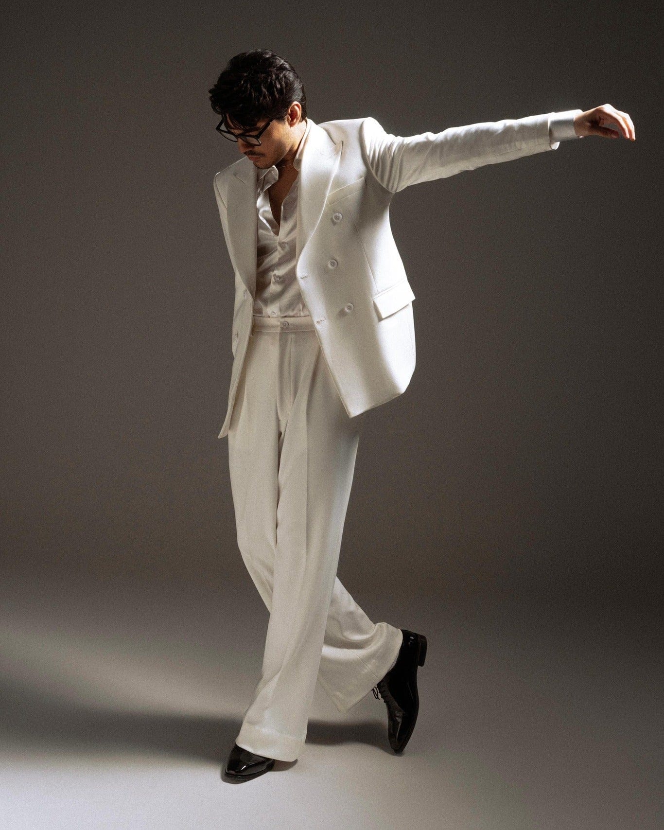 Person wearing a white suit with a gray background