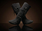 Dual wrap-and-tie strap closure on black suede Noirtide Renaissance boot — metal rivet anchors, genuine suede leather