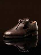 Side profile dark brown leather open latchet shoe — open sides, high tongue — Noirtide 17th century footwear