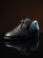 Side view of black leather open latchet shoe — open quarter, high tongue, welted sole — Noirtide