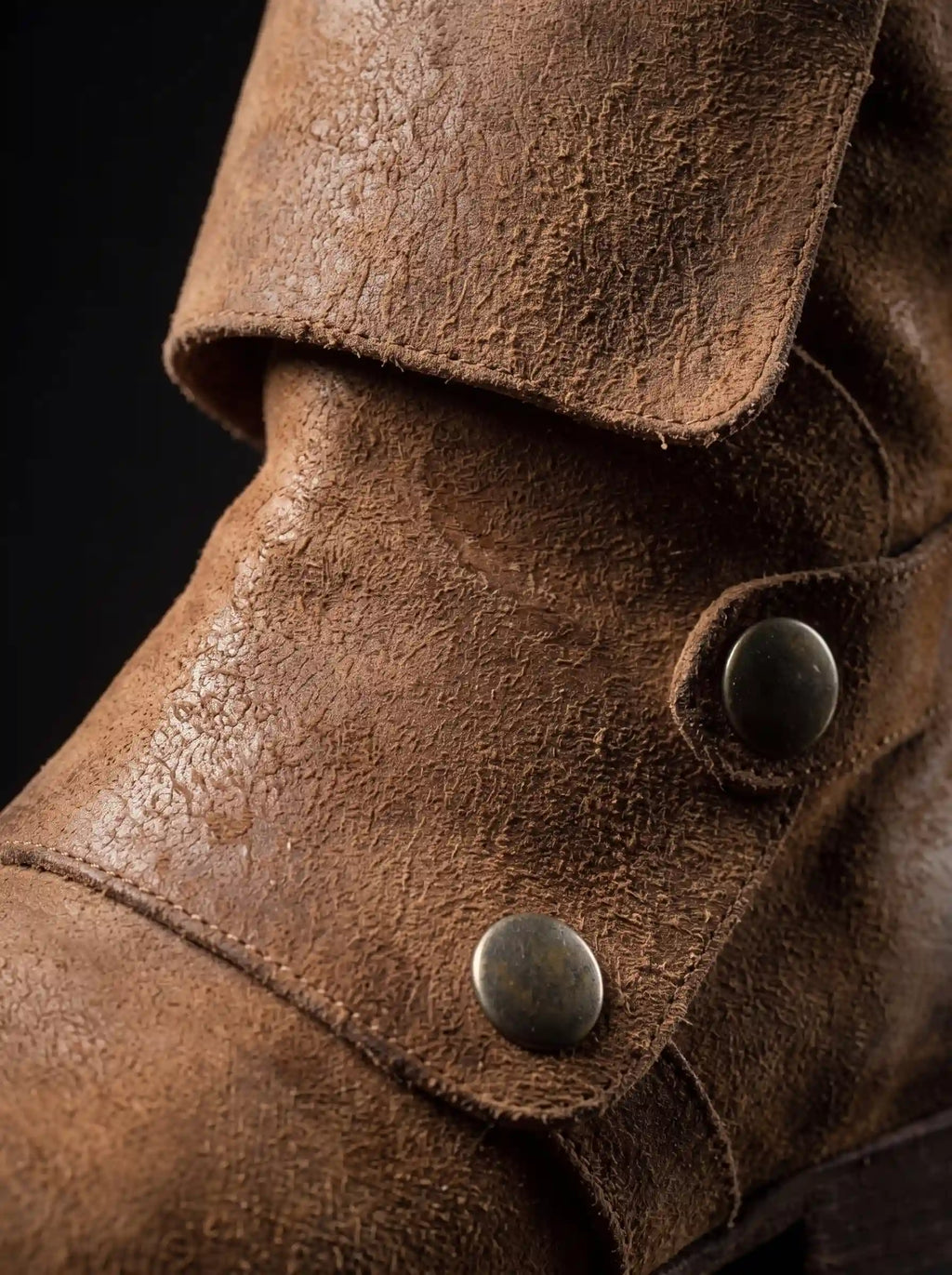 Antique brass snap button on outside of Noirtide Flynn Rider boot shaft — distressed brown leather, genuine construction
