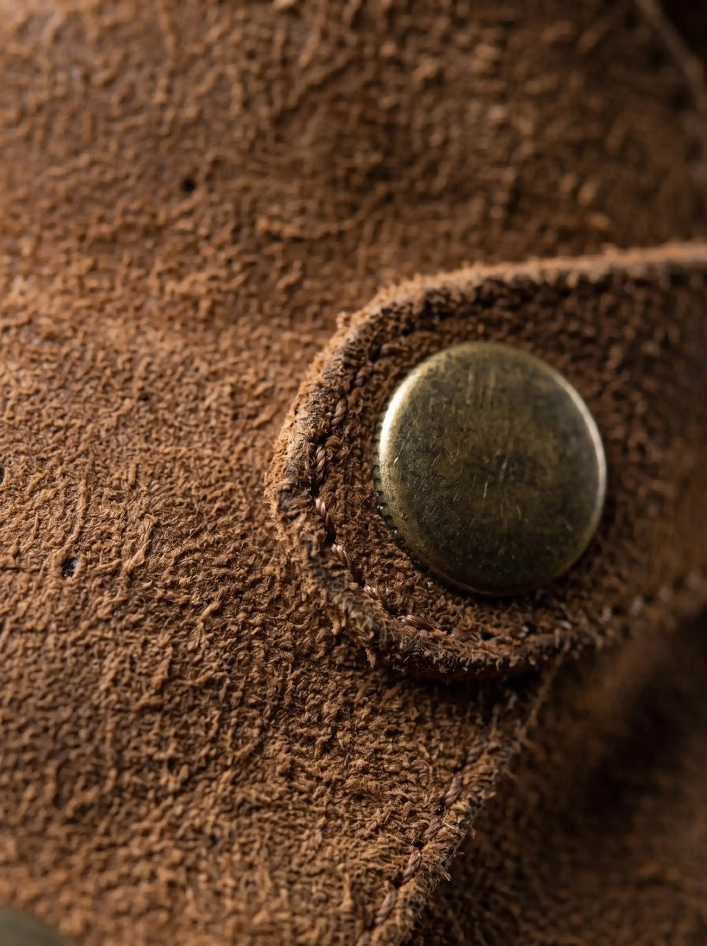 Antique brass snap button on inside of Noirtide Flynn Rider boot shaft — double-sided closure detail, brown leather